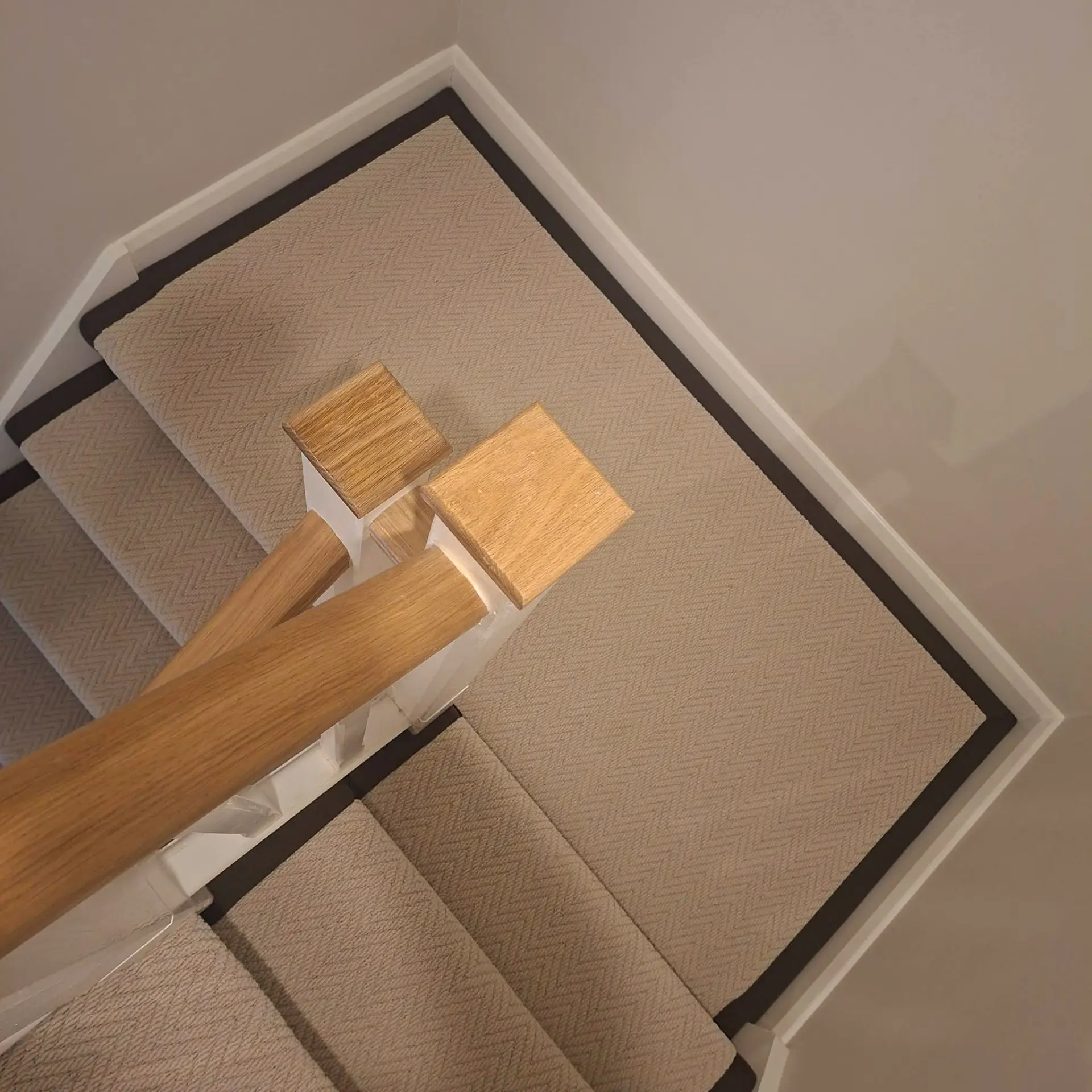 Herringbone stair runner with wooden stair rods and dark binding