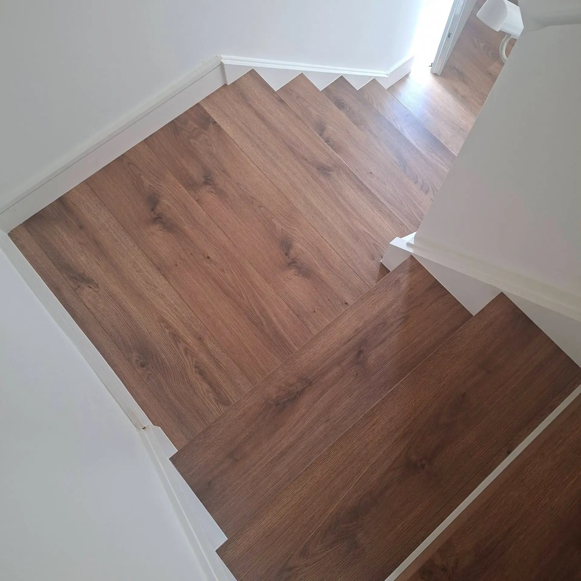 Dark oak clad staircase with winder treads and white risers